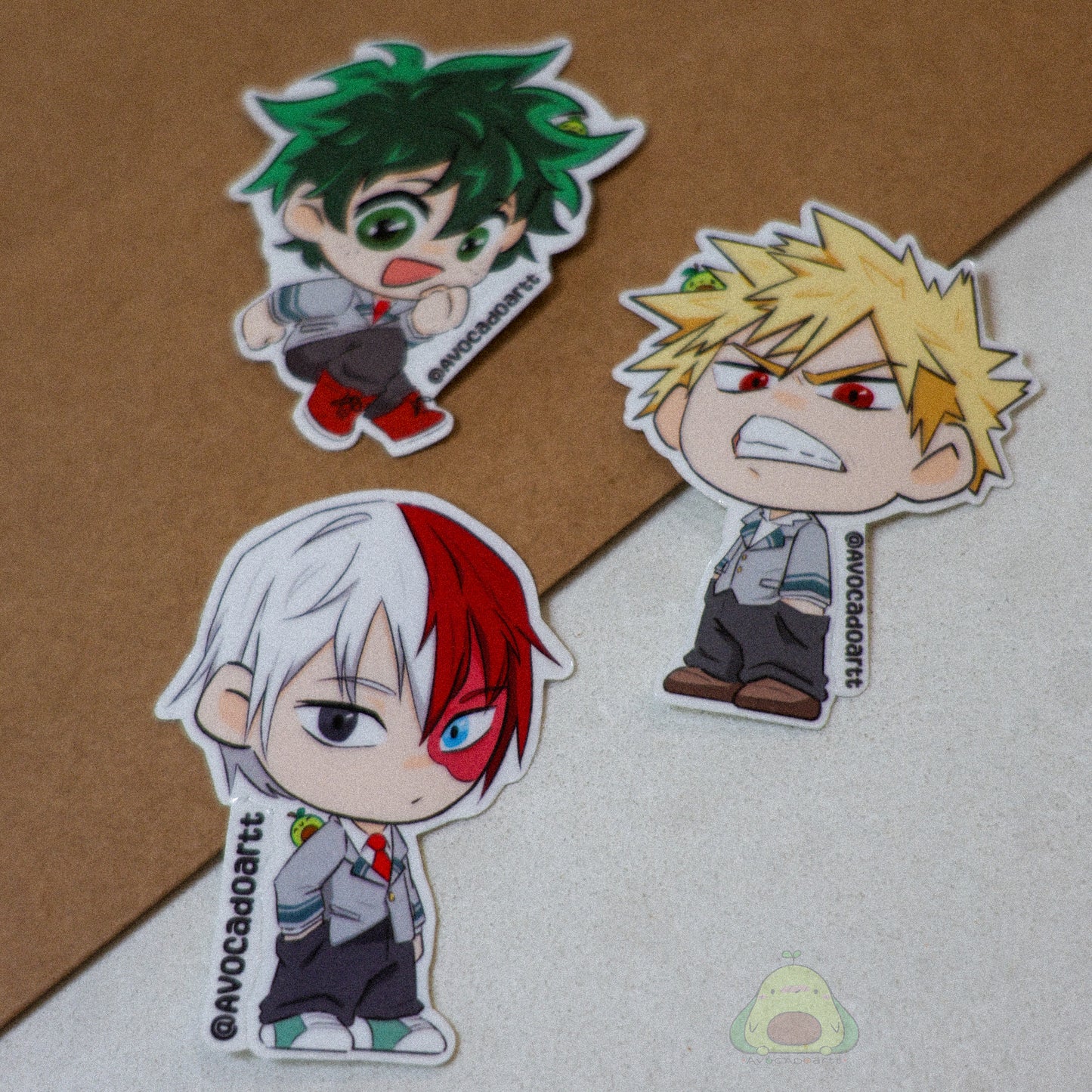 Handmade vinyl stickers of Bakugo, Midoriya, and Todoroki from My Hero Academia, illustrated by Avocado Artt in a cohesive trio design featuring each hero in their signature poses and outfits.